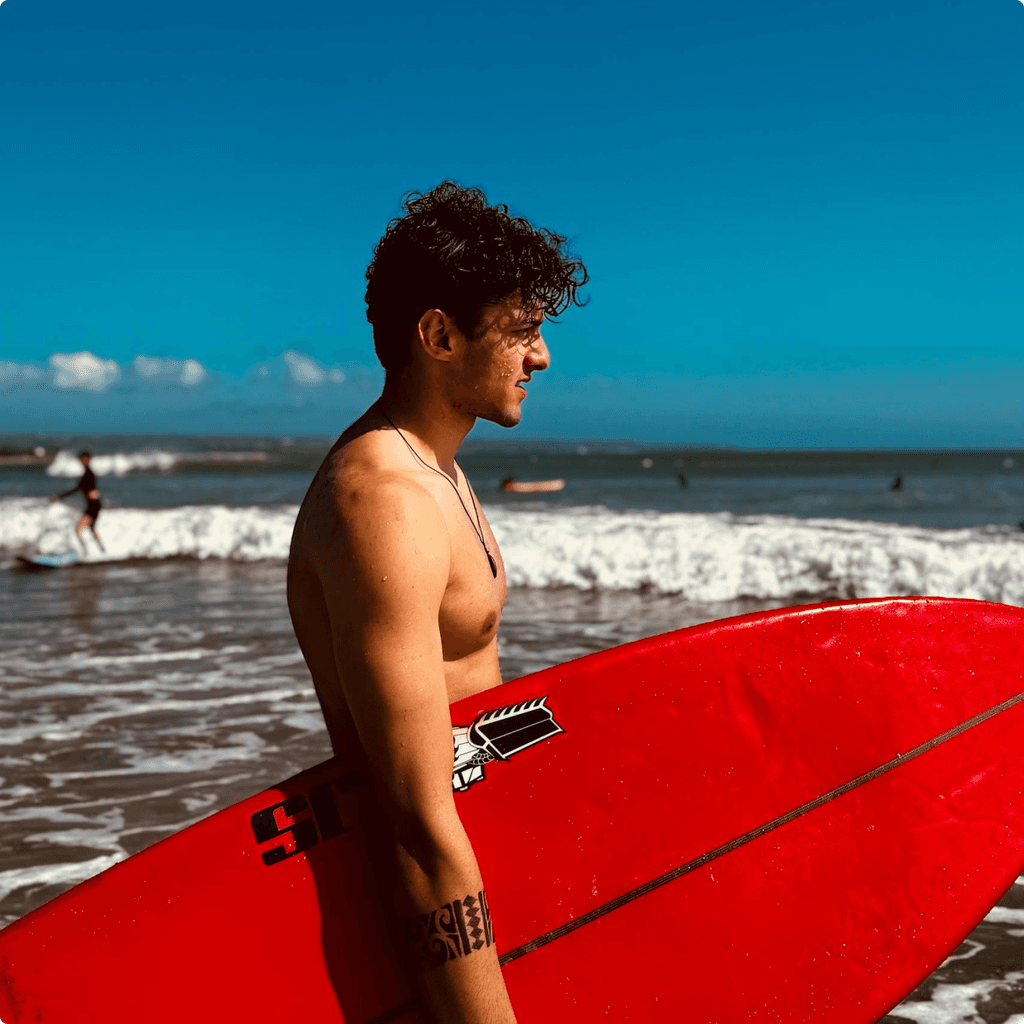 A man stading with Surfboard